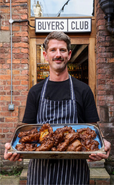A chef holding a tray of fresh Yorkshire puddings
