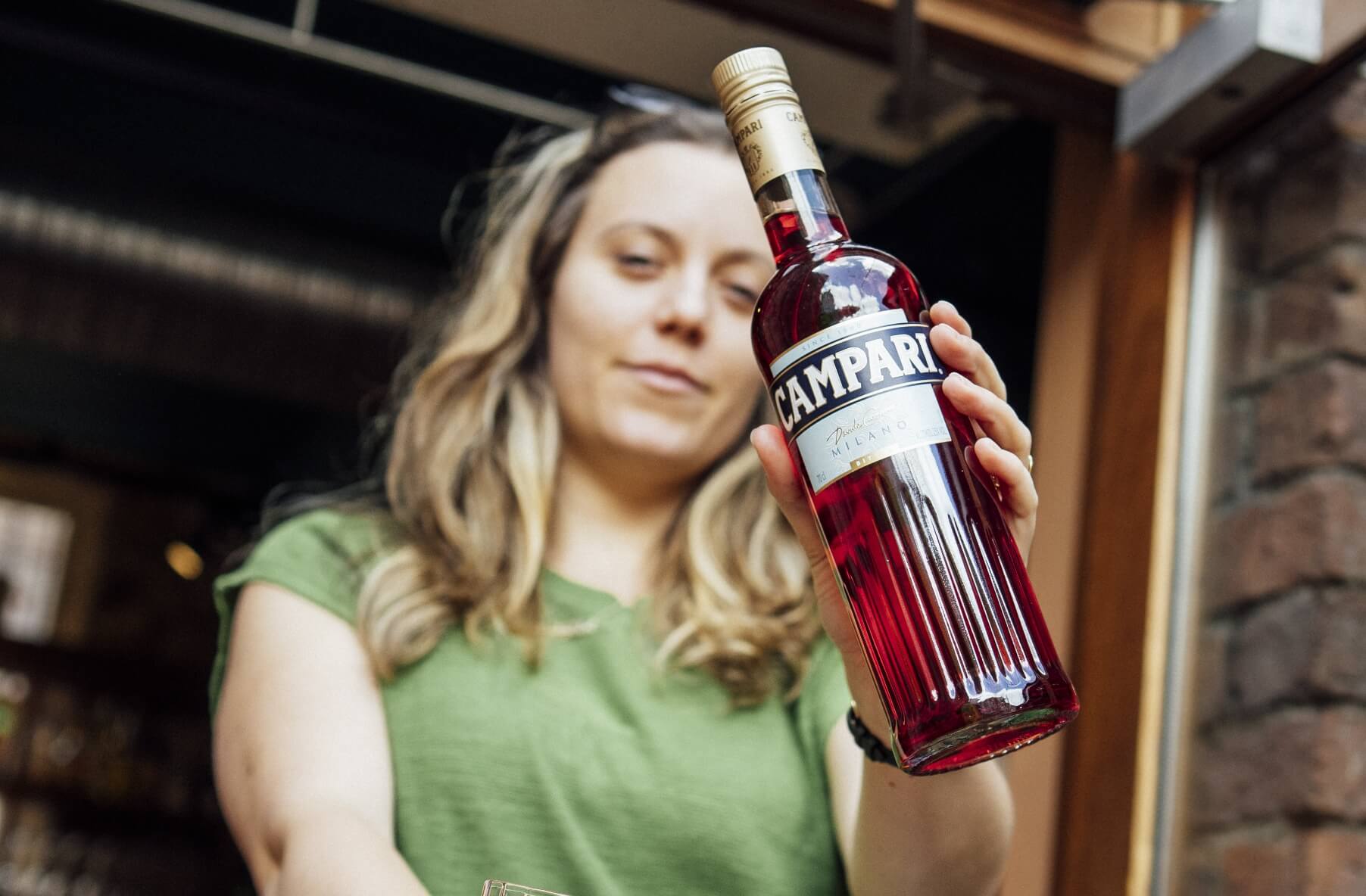 A woman holding up a bottle of wine