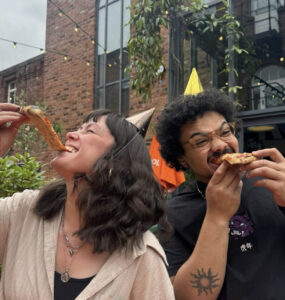 Two young people enjoying a slice of pizza